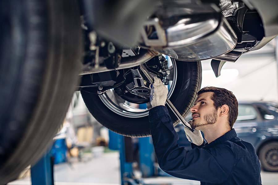 Specialized Business Insurance - Mechanic Examining Car Suspension at an Auto Car Repair Service Center